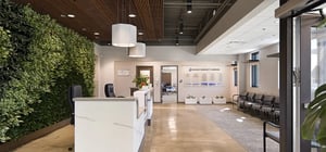 Side angle view of a modern entry receptionist area with faux plant feature wall