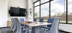 Corporate conference room with head table and chairs and a large tv on the wall