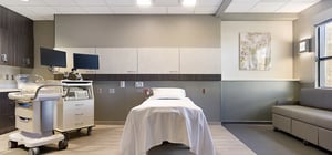 Modern large OB patient room with comfortable seating and relaxing decor.