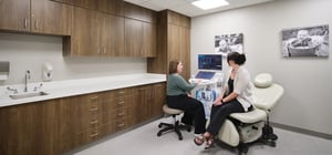 Midwife exam room for ultrasounds with 2 women using technology
