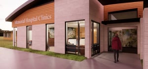 Architectural rendering of the exterior entrance of a modern medical facility at dawn