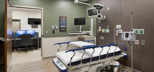 Modern ER patient room near nurse station with medical equipment