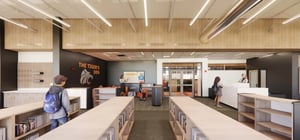 Architectural rending of a modern elementary school media center with book shelves and students