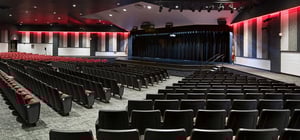 Modern high school auditorium with theater style seating and modern architecture style