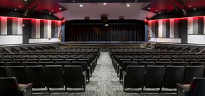 Modern high school auditorium with theater style seating and modern architecture style